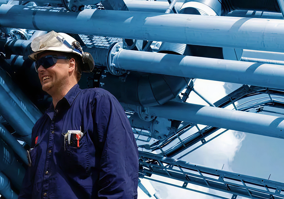 Engineers discussing near large metal pipes